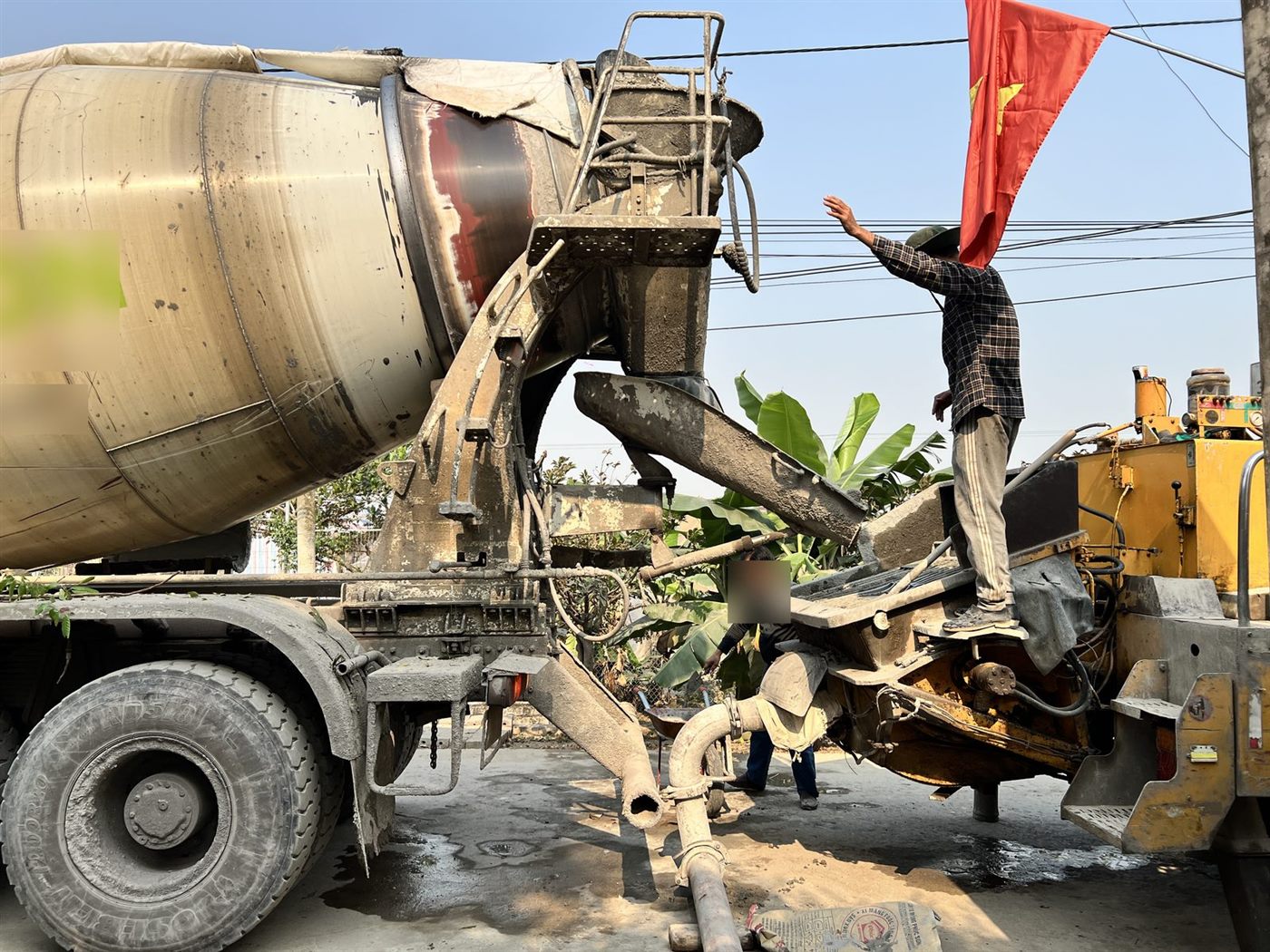 Xe bê tông tươi xả vào máy bơm khi đổ bê tông móng nhà dân