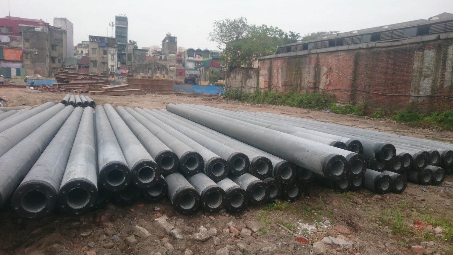 Cọc bê tông ly tâm tiết diện tròn rỗng tập kết thành đống tại công trường, nhìn rõ mặt cắt đầu cọc và chiều dày thành cọc