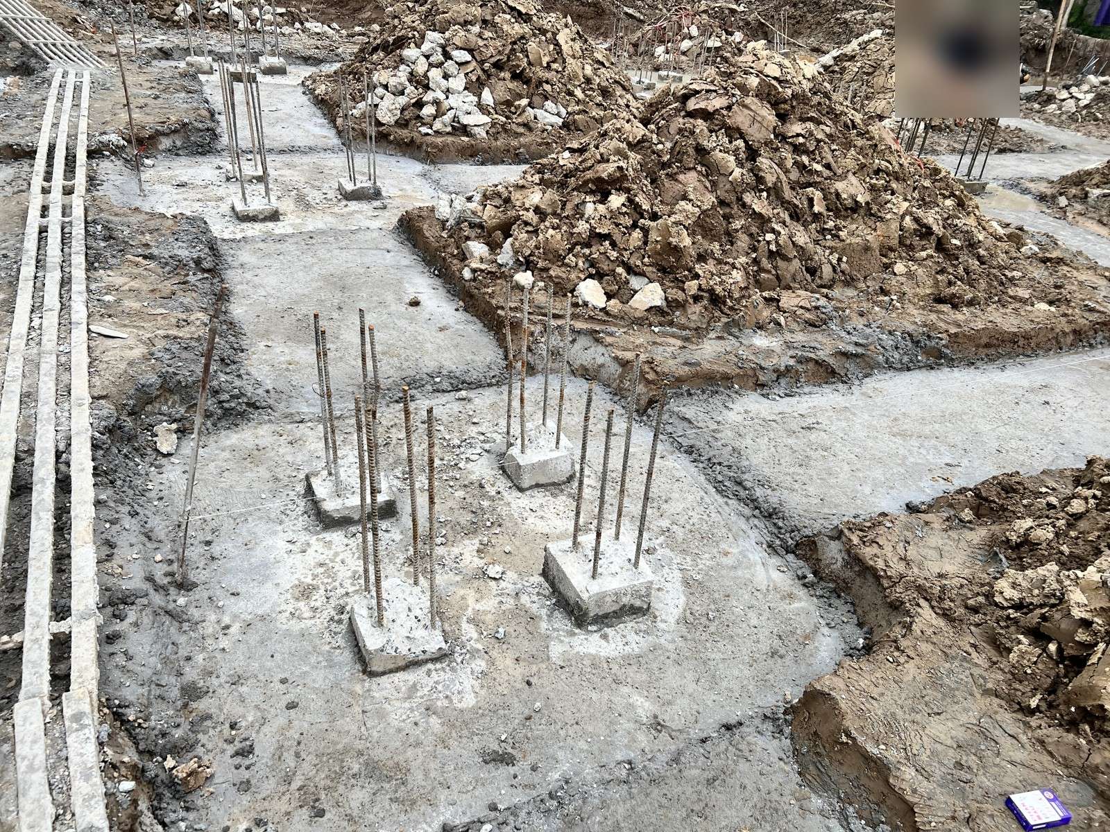 Đáy móng nhà dân khô, lớp bê tông lót đã đổ quanh các đầu cọc, thép chờ nhô lên