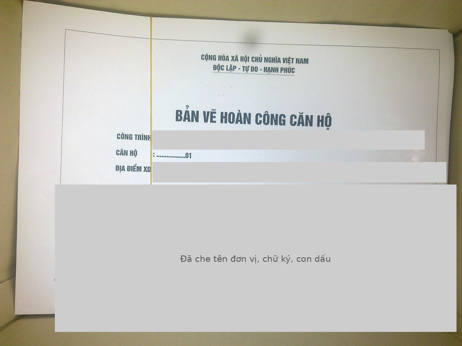Bìa một tập bản vẽ hoàn công, phần tên công trình, địa điểm, đơn vị ký và con dấu đã được che