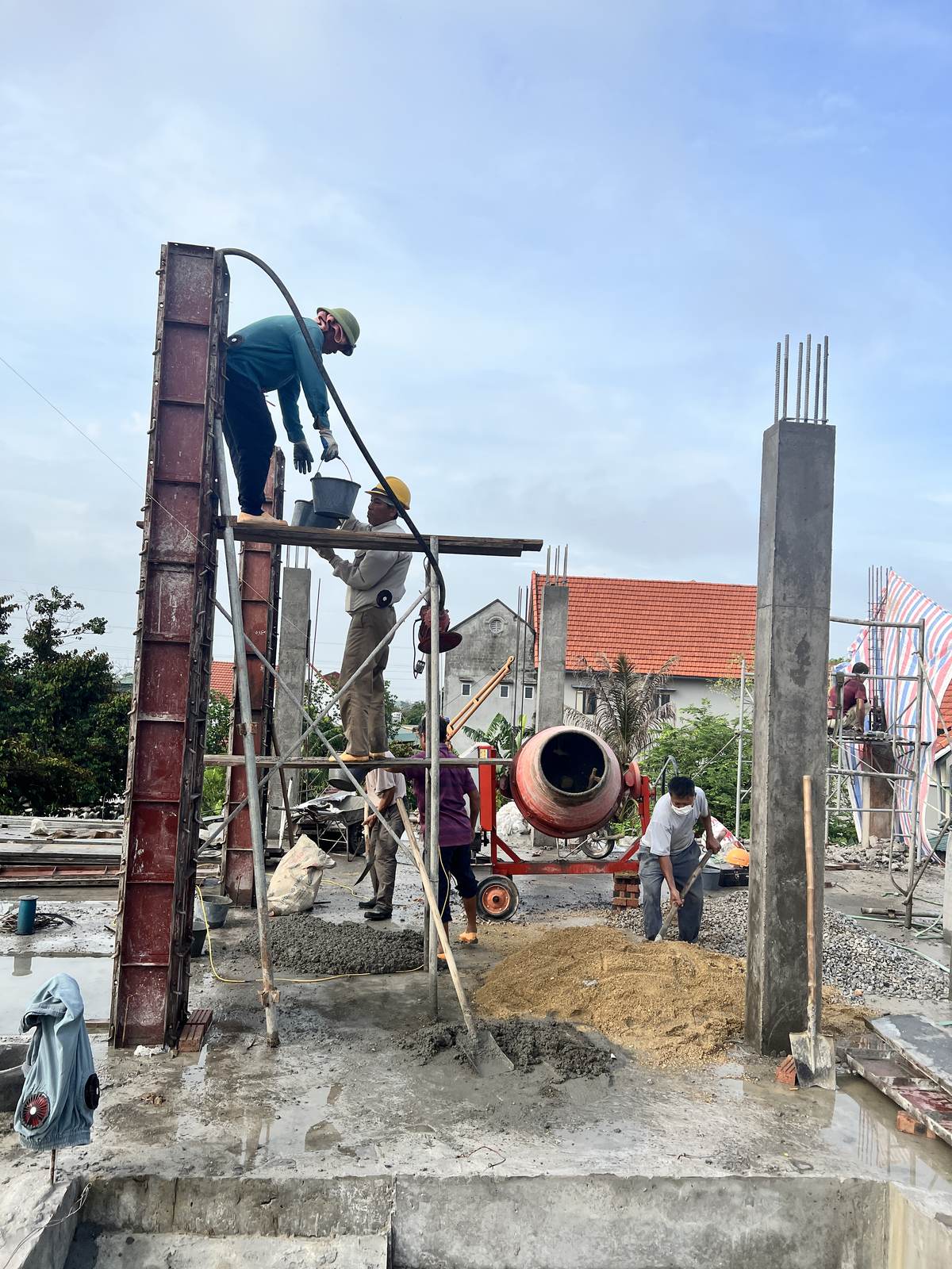 Thợ đang thi công phần thô nhà dân, máy trộn bê tông và vật liệu tập kết ngay tại công trường
