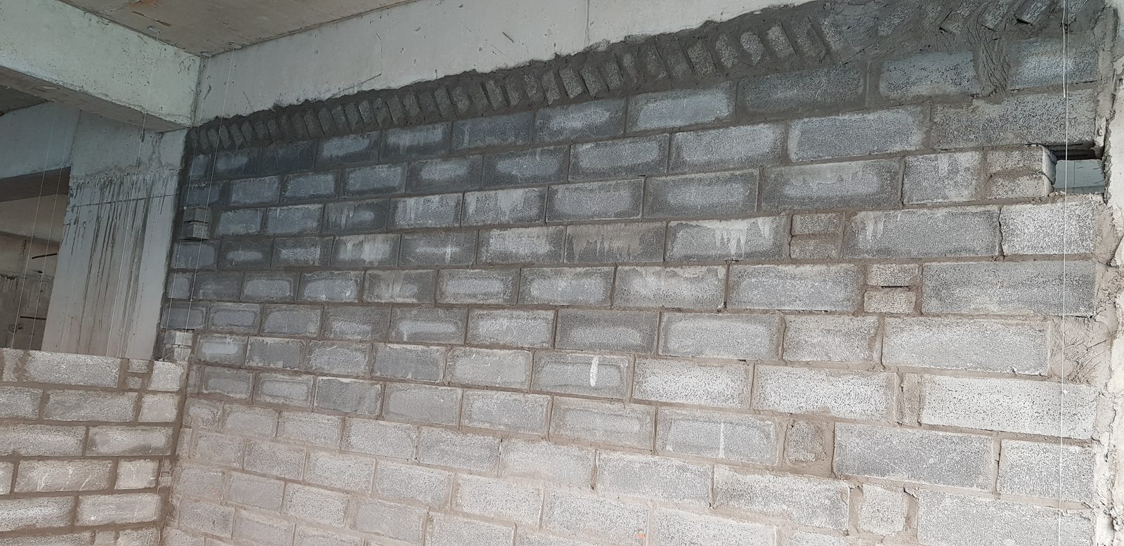 Phần đỉnh tường khối xây được chèn bằng một hàng gạch xây nghiêng giáp đáy dầm bê tông
