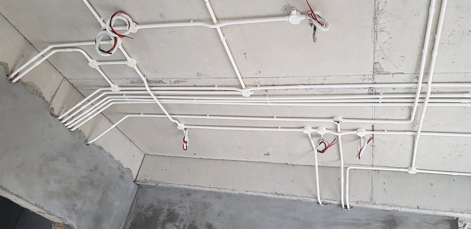 Toàn bộ tuyến ống điện nước còn lộ trên tường và trần, chờ nghiệm thu trước khi trát che kín