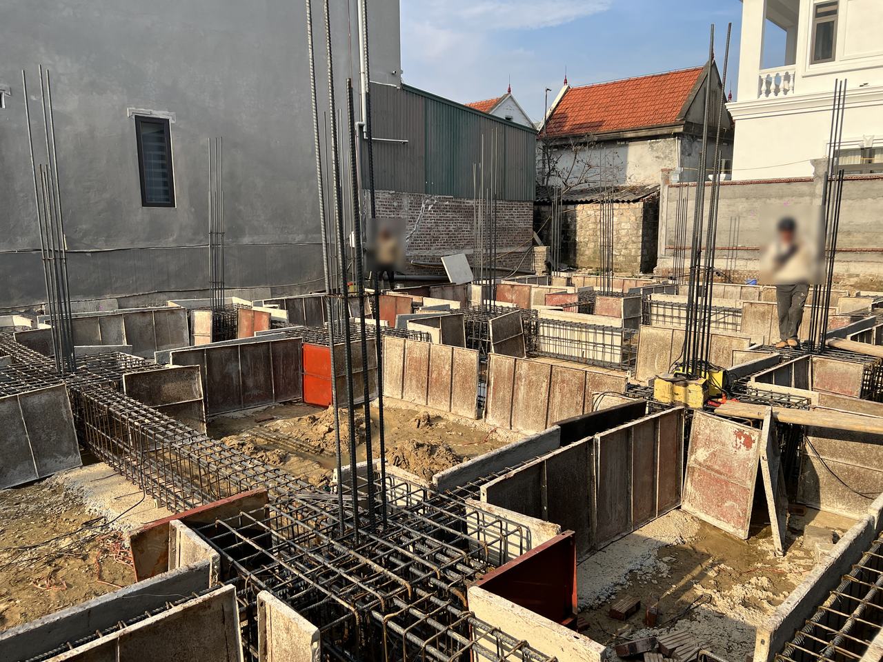 Lồng thép giằng móng chạy vào hộp cốp pha đài có thép chờ cột dựng đứng, các tuyến cốp pha giằng xung quanh