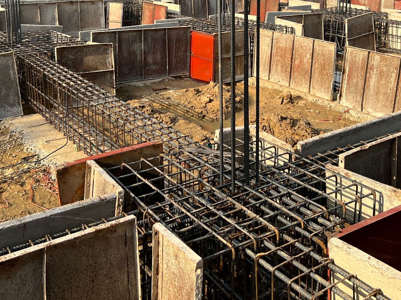 Lồng thép giằng móng chạy vào lồng thép đài cọc, thép chờ cột dựng đứng giữa đài, cốp pha thép đã ghép xung quanh