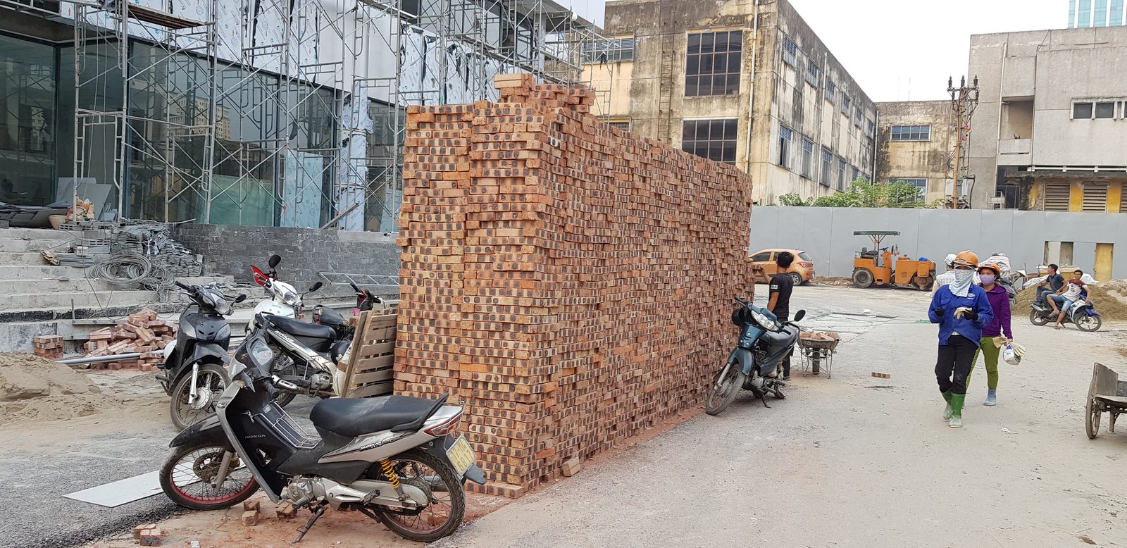 Gạch đất sét nung xếp thành đống lớn tại công trường, chờ kiểm tra kích thước và chất lượng trước khi xây