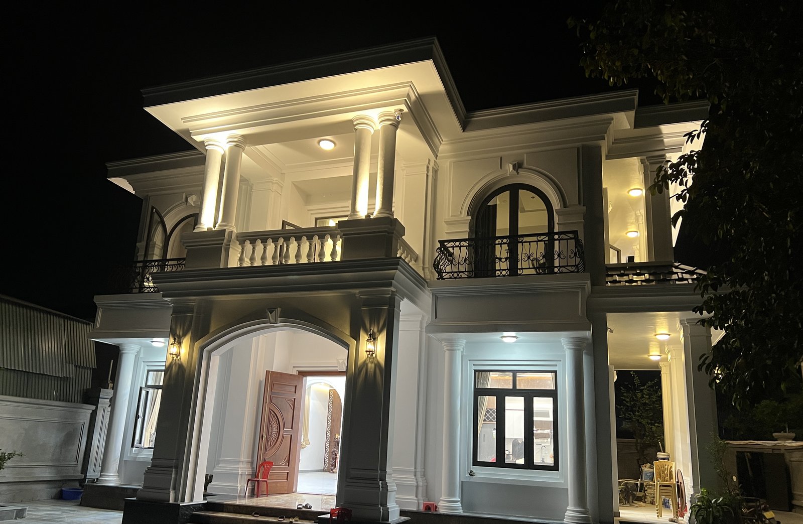 Ngôi nhà đã hoàn thiện, chụp buổi tối, đèn hắt sáng mặt tiền