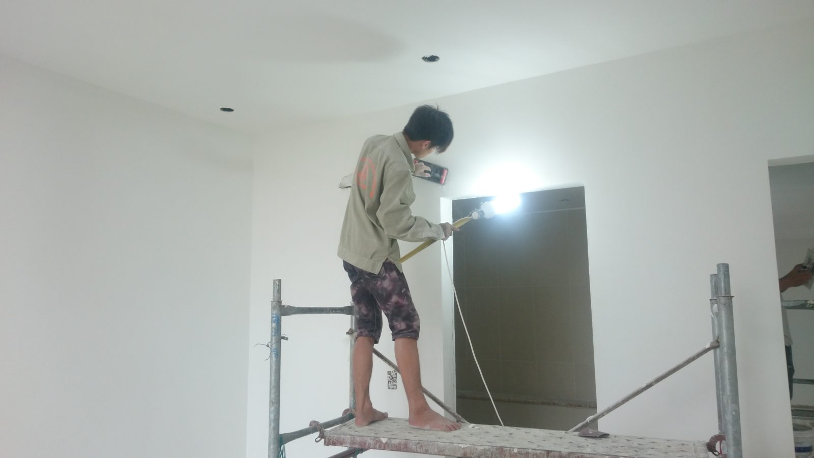 Mảng tường và mép cửa đã bả phẳng, các cạnh thẳng và sắc nét trước khi bước sang sơn
