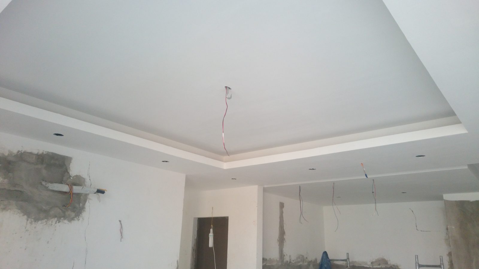 Mảng vá vữa quanh ống và vết nứt lộ rõ trên mặt tường đã bả, cần xử lý trước khi sơn