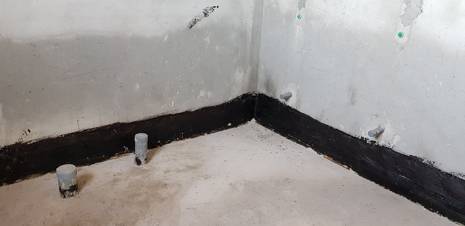 Lớp chống thấm quét phủ lên chân tường và bo góc quanh cổ ống xuyên sàn nhà vệ sinh