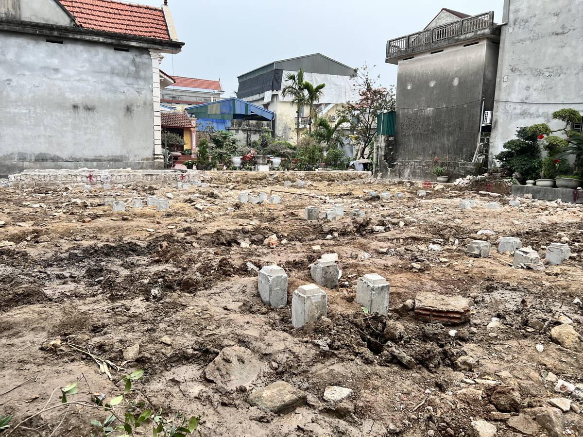 Mặt bằng nhà dân sau khi ép cọc, các đầu cọc bê tông vuông nhô lên khỏi nền đất với chiều cao không đều nhau