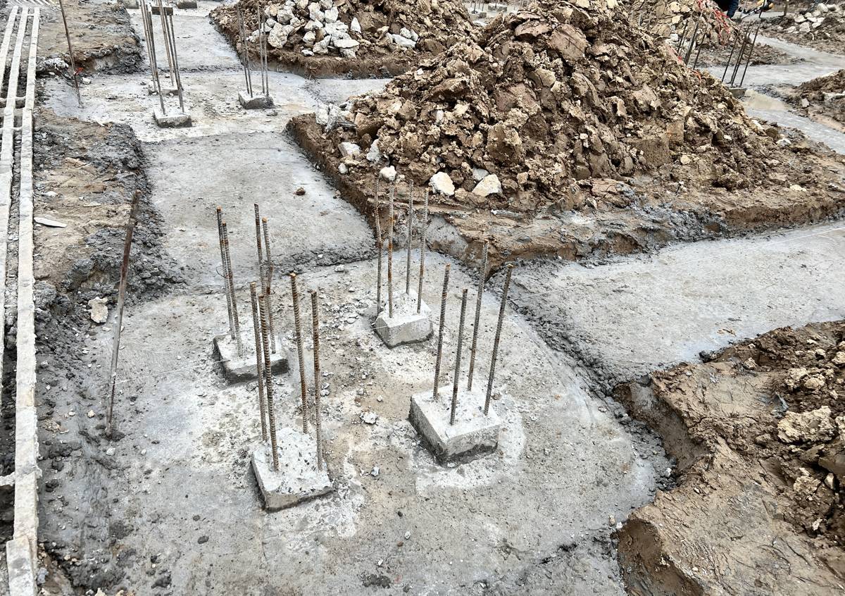 Bốn đầu cọc bê tông vuông trong hố đài nhà dân sau khi xử lý, cốt thép dọc của cọc lộ ra phía trên lớp bê tông lót